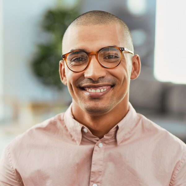 Headshot of young adult man with glasses smiling