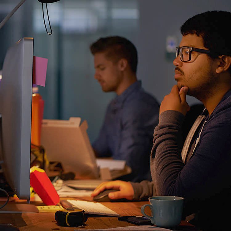 Man touching his chin looking at his computer screen.