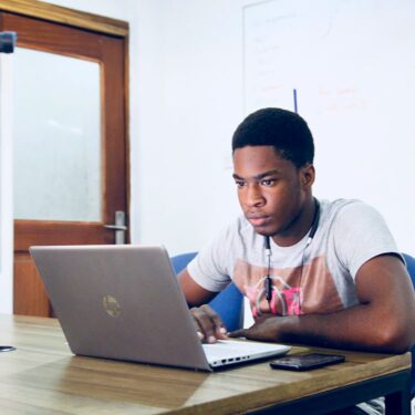 A person researching VET TEC program funding on a computer.