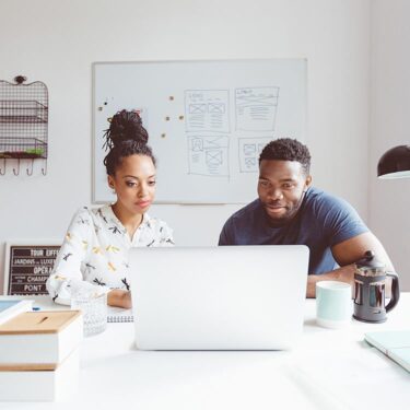 Man and woman looking at a laptop together.