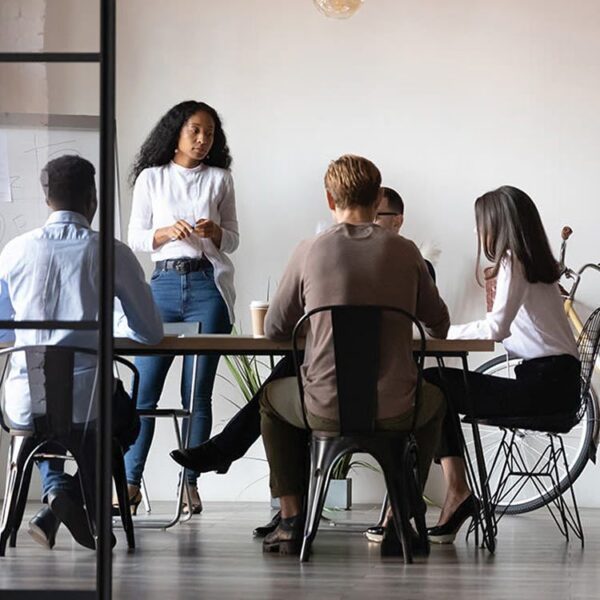 Five men and women sitting around a table talking.