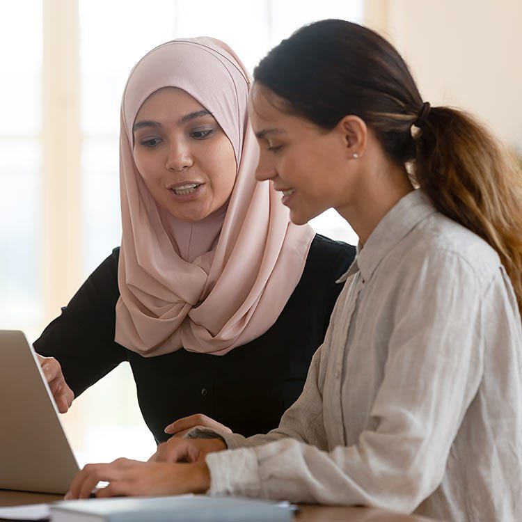 Two women working together on a laptop.