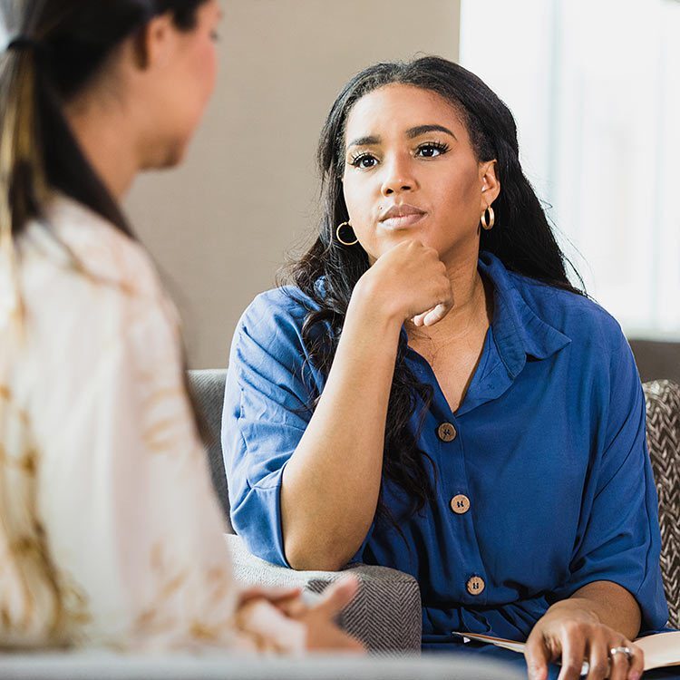 Woman intently listening to another woman speak.