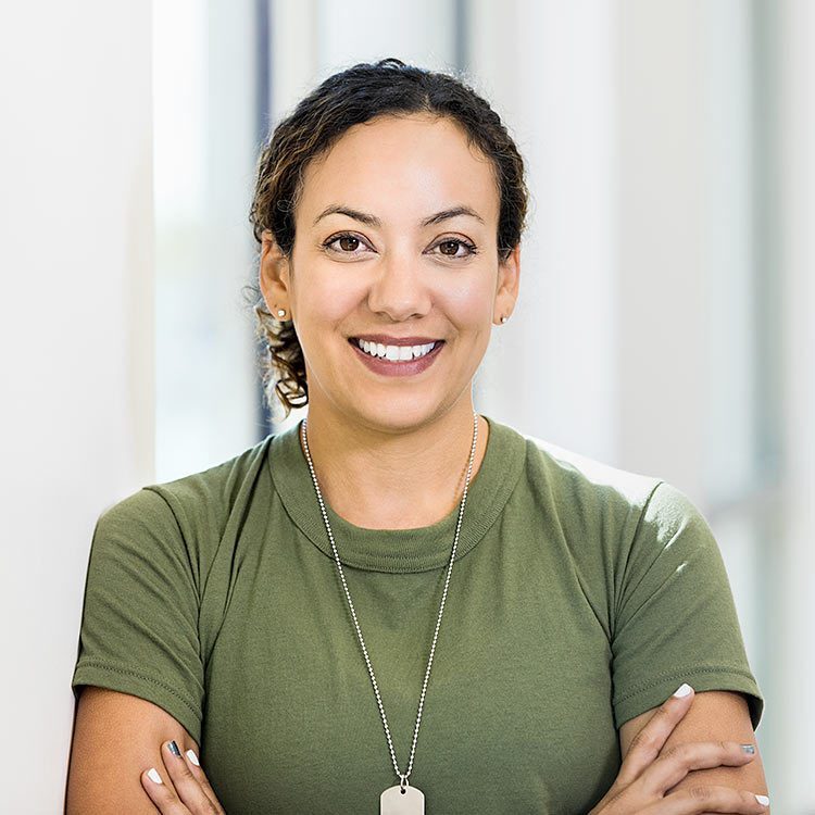 woman smiling at the camera in military uniform.