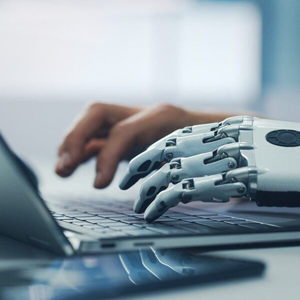 prosthetic hand typing on laptop keyboard.