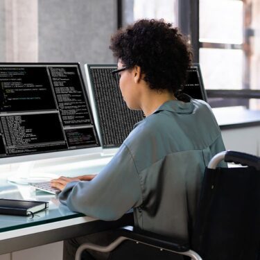 African American woman coding on her computer monitor.