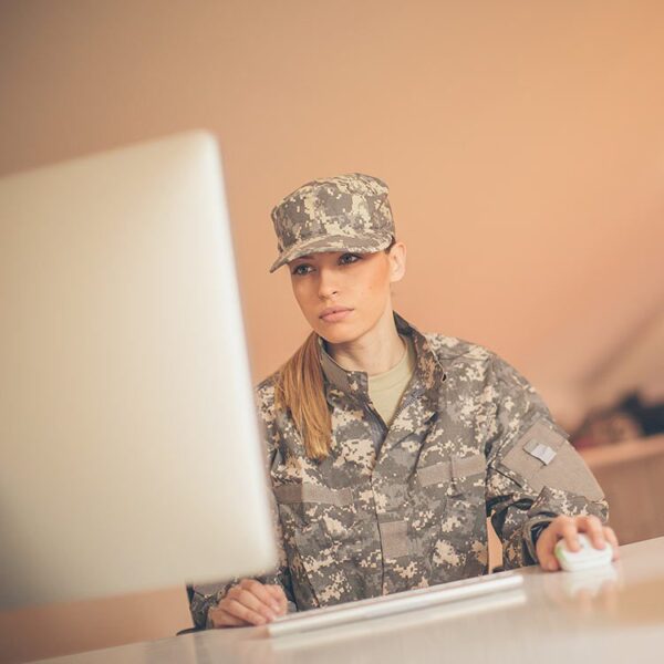 Woman in military uniform working on computer.