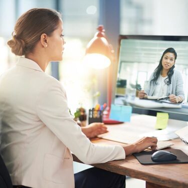 Woman speaking to another woman on video conference at work.